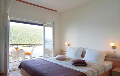 a bedroom with a large bed with a large window at Beautiful Apartment In Rabac With House Sea View in Raša