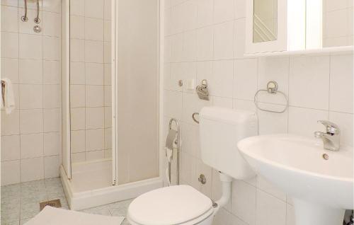 a white bathroom with a toilet and a sink at Beautiful Apartment In Rabac With House Sea View in Raša