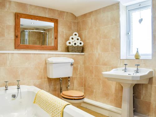 een badkamer met een toilet, een wastafel en een bad bij Chapel Cottage in Robin Hood's Bay