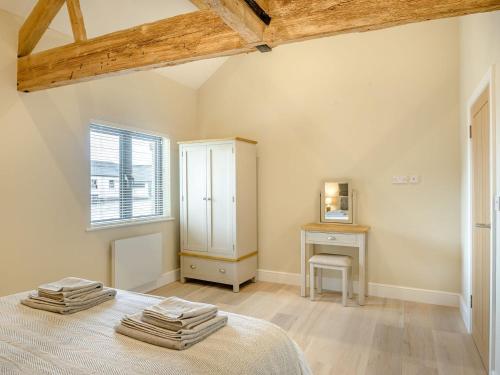 a bedroom with a bed and a desk and a window at The Ash - Arnolds Hill in Wingfield