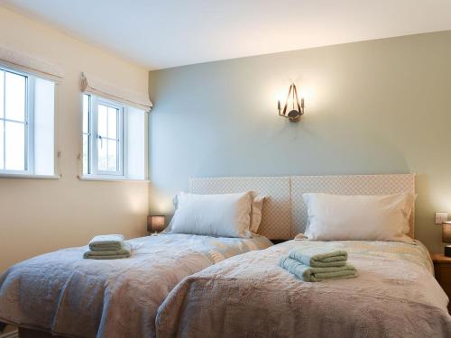 a bedroom with two beds with towels on them at Duck Cottage in Tholthorpe