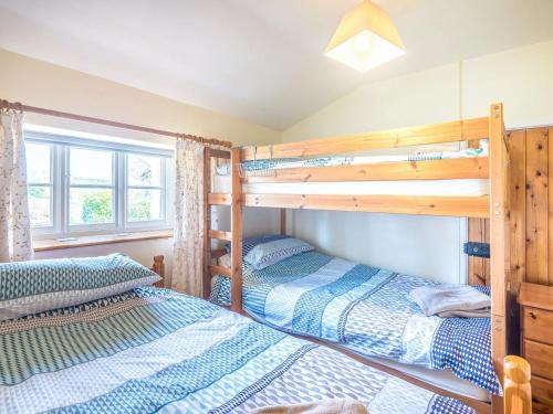 a bedroom with two bunk beds and a window at Well Farmhouse - Uk11880 in North Tamerton