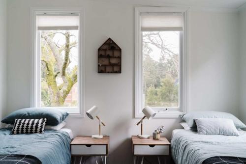 two beds in a room with two windows at The Church at Lyonville - Daylesford Region in Lyonville