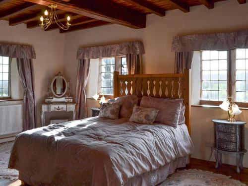 a bedroom with a large bed in a room with windows at Dairy House Farm in Horton