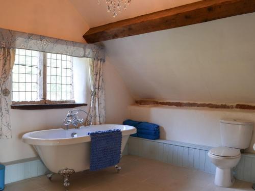 a bathroom with a white tub and a toilet at Dairy House Farm in Horton