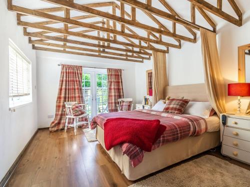 a bedroom with a large bed with a wooden ceiling at The Little House In Hull in Hull