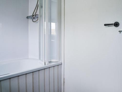 a shower with a glass door in a bathroom at Needle Cottage in Cullen