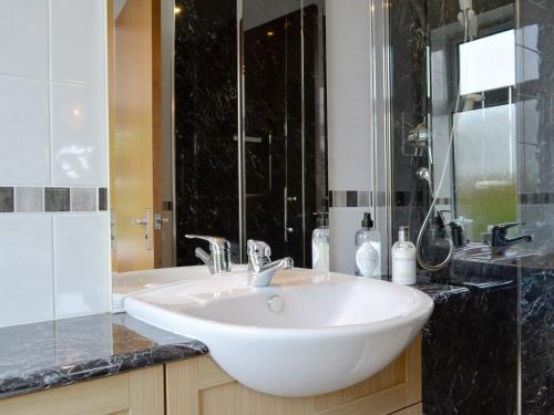 y baño con lavabo blanco y ducha. en Sauchenshaw Cottage, en Maryculter