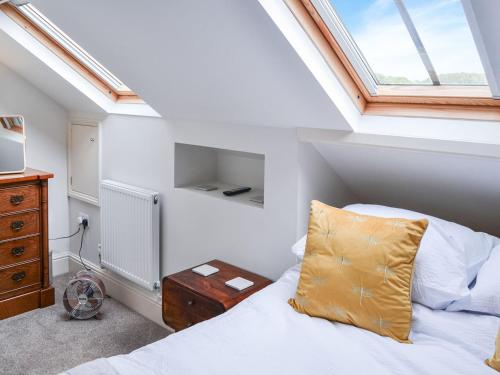 a attic bedroom with a bed and a window at 1 Alexandra Villa in Coltishall