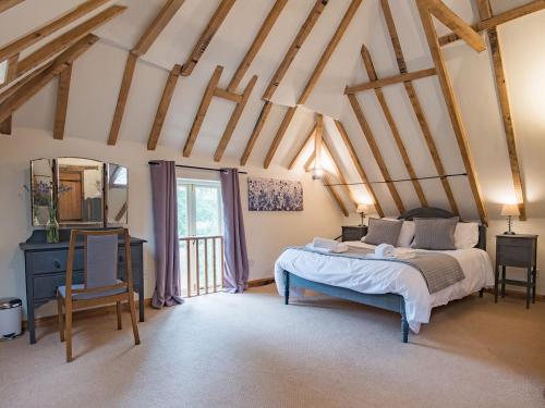 a bedroom with a bed and a table and a mirror at Kingfisher Oast in Hollingbourne