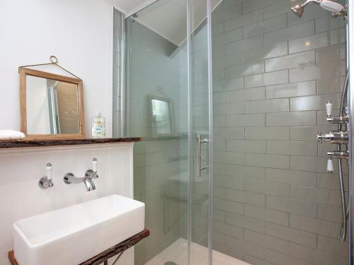 a bathroom with a sink and a glass shower at The Hayloft - Uk32686 in Sheepstor