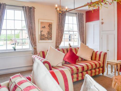 un soggiorno con divano e finestre di Highbury Farm Cottage a Wharram le Street