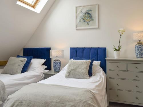 two beds in a room with blue and white at Old Parish Hall in Ramsgate