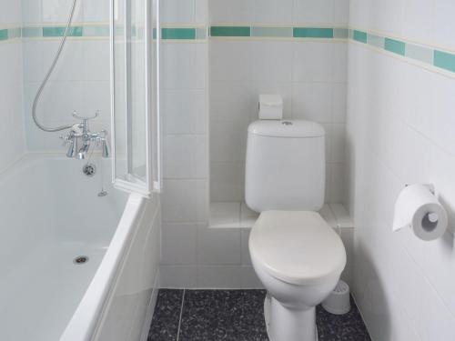 uma casa de banho com um WC branco e um chuveiro em High Brow em Bowness-on-Windermere