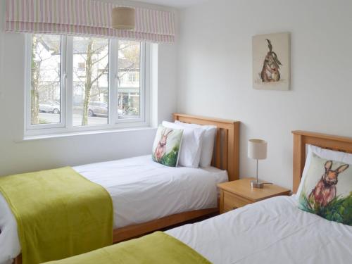 um quarto com 2 camas e uma janela em High Brow em Bowness-on-Windermere