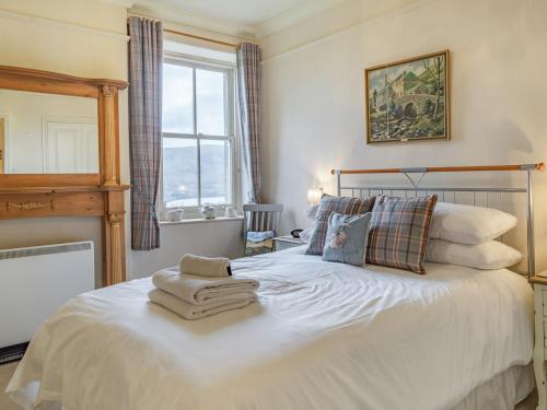 - une chambre avec un lit blanc et des serviettes dans l'établissement Mell Fell, à Watermillock