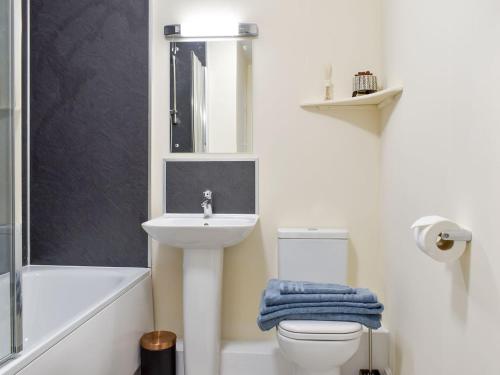 a bathroom with a sink and a toilet and a mirror at Three Dorchester Drive - Uk32039 in Inglewhite