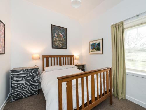 a bedroom with a bed and a window at Edmonston Lodge in Elsrickle