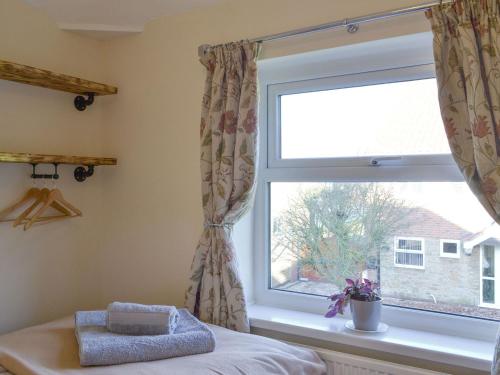 ein Fenster in einem Schlafzimmer mit einem Bett und einem Fenster in der Unterkunft Bennys Cottage in Hotham