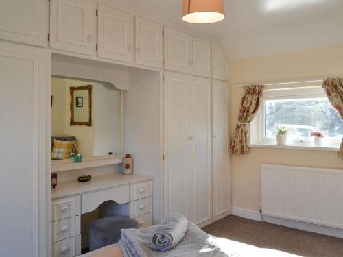 a bedroom with a bed and a desk and a window at Bennys Cottage in Hotham