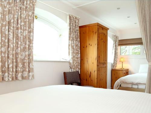 a bedroom with a bed and a window at Garden Cottage in Icklesham