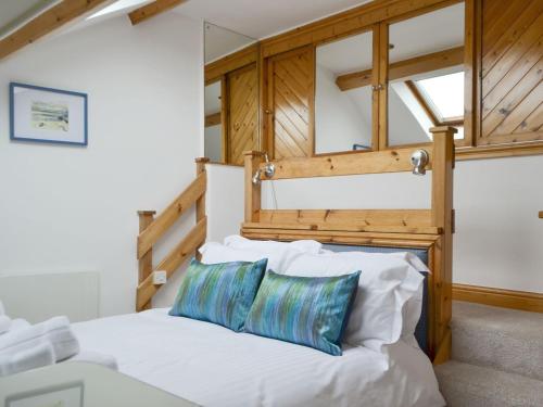 a bedroom with a white bed with a wooden headboard at Lane Foot Barn in Dean