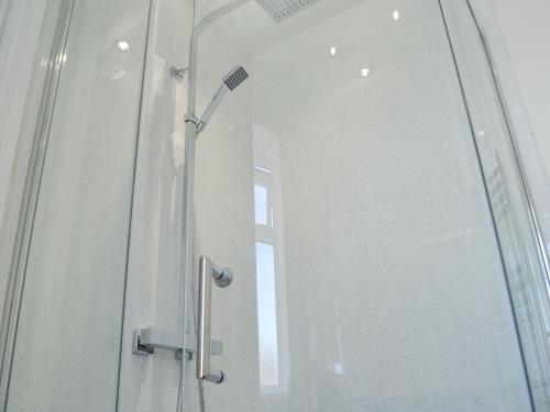 ducha con puerta de cristal y ventana en Forest Walk, en Coleford