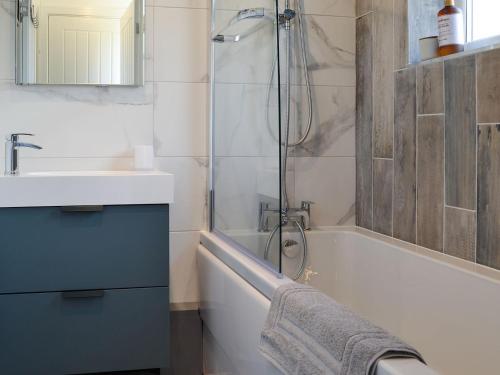 a bathroom with a tub and a sink and a shower at Ty Canol in Llansaint