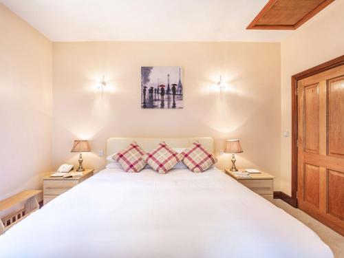 - une chambre avec un grand lit blanc et 2 tables de chevet dans l'établissement Garden Cottage - Uk34669, à Great Corby