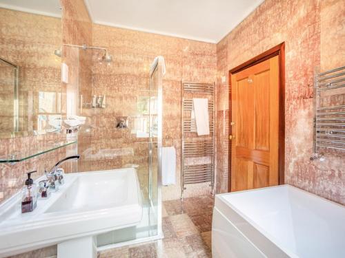 uma casa de banho com um lavatório, um chuveiro e uma banheira em Garden Cottage - Uk34669 em Great Corby