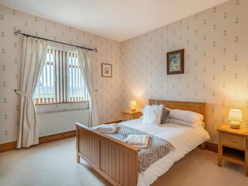 a bedroom with a large bed and a window at Highfield Cottage in Hambleton