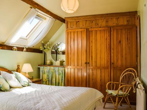 Broom的住宿－Saxon Barn，一间卧室配有一张床和一个木制橱柜