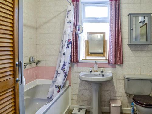 a bathroom with a sink and a tub and a toilet at Ardencaple No 2 in Castle Douglas
