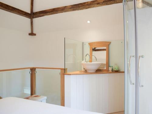 a bathroom with a glass shower and a sink at Pepperpot Lodge in Baschurch