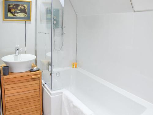 La salle de bains est pourvue d'une baignoire blanche et d'un lavabo. dans l'établissement Mill Pond View, à Ceres