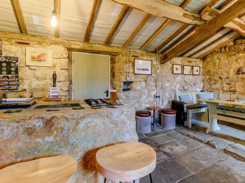 a room with a stone wall and a table and stool at The Nook - Uk36720 in Glaisdale