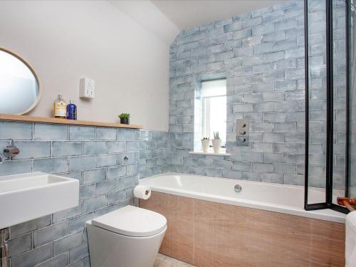 uma casa de banho com uma banheira, um WC e um lavatório. em Old Farm em Barton Saint David