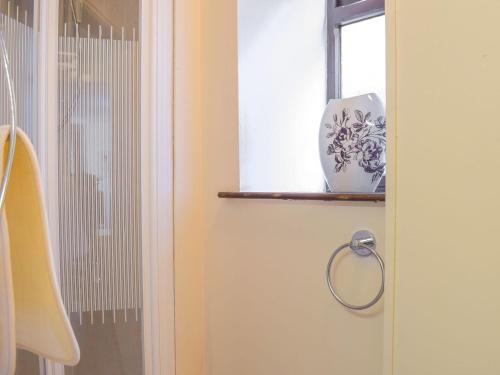 a door with a handle and a vase on a window at Border View in Kington