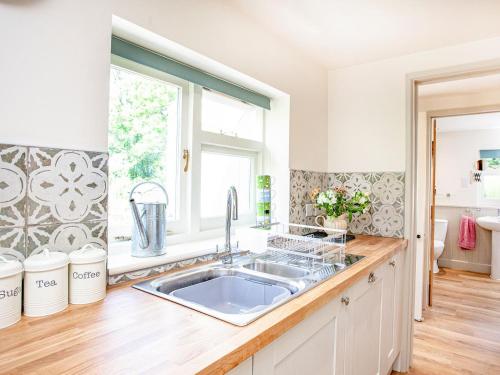 a kitchen with a sink and a window at Splash Cottage in Widecombe in the Moor