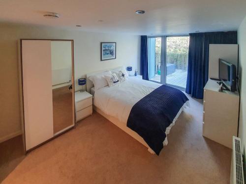 a bedroom with a large bed and a television at Apartment 4, Zinc in Newquay