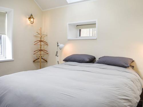 um quarto com uma cama com duas almofadas azuis em The Bothy em Kirktown of Auchterless