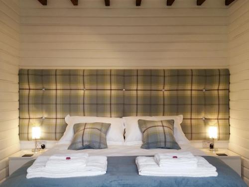 a bedroom with a bed with two towels on it at Field House Lodge in Borrowdale