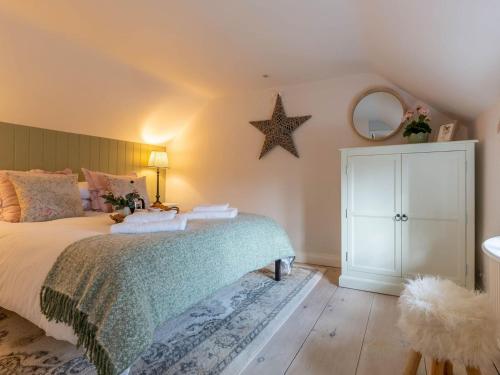 a bedroom with a bed with a star on the wall at Church Cottage in Thurlton