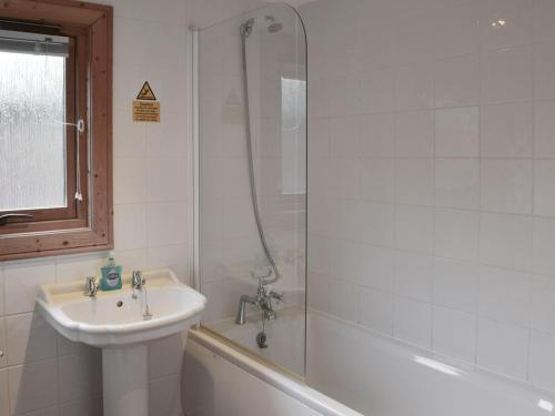 a bathroom with a sink and a shower and a bath tub at Holme Garth Lodge in Legbourne