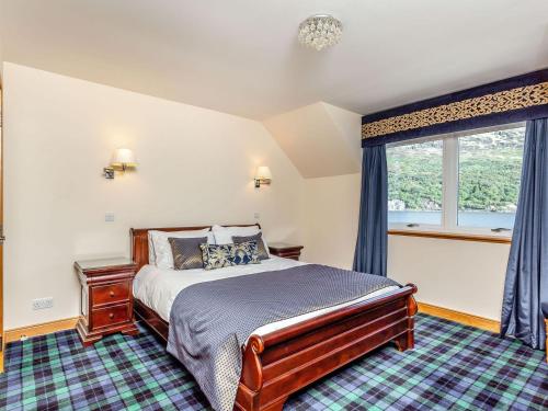 a bedroom with a bed and a window at Lochside House - S4532 in Letterfearn