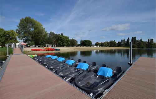 a row of chairs on a dock on a lake at Awesome Home In St Pierre En Auge in Vieux-Pont-En-Auge