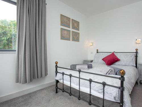 洛克斯頓的住宿－The Walled Garden，一间卧室配有一张带红色枕头的床和一扇窗户