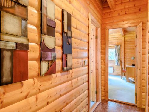 a hallway in a log cabin with paintings on the wall at Cherry Lodge- Uk37608 in Legbourne