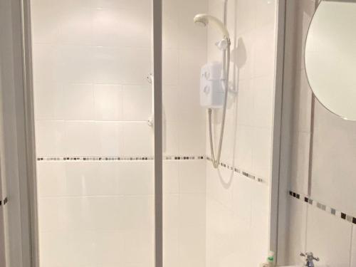 W łazience znajduje się prysznic ze szklanymi drzwiami. w obiekcie Honeypot Cottage w mieście Maresfield