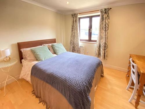 a bedroom with a bed and a window and a desk at Honeypot Cottage in Maresfield